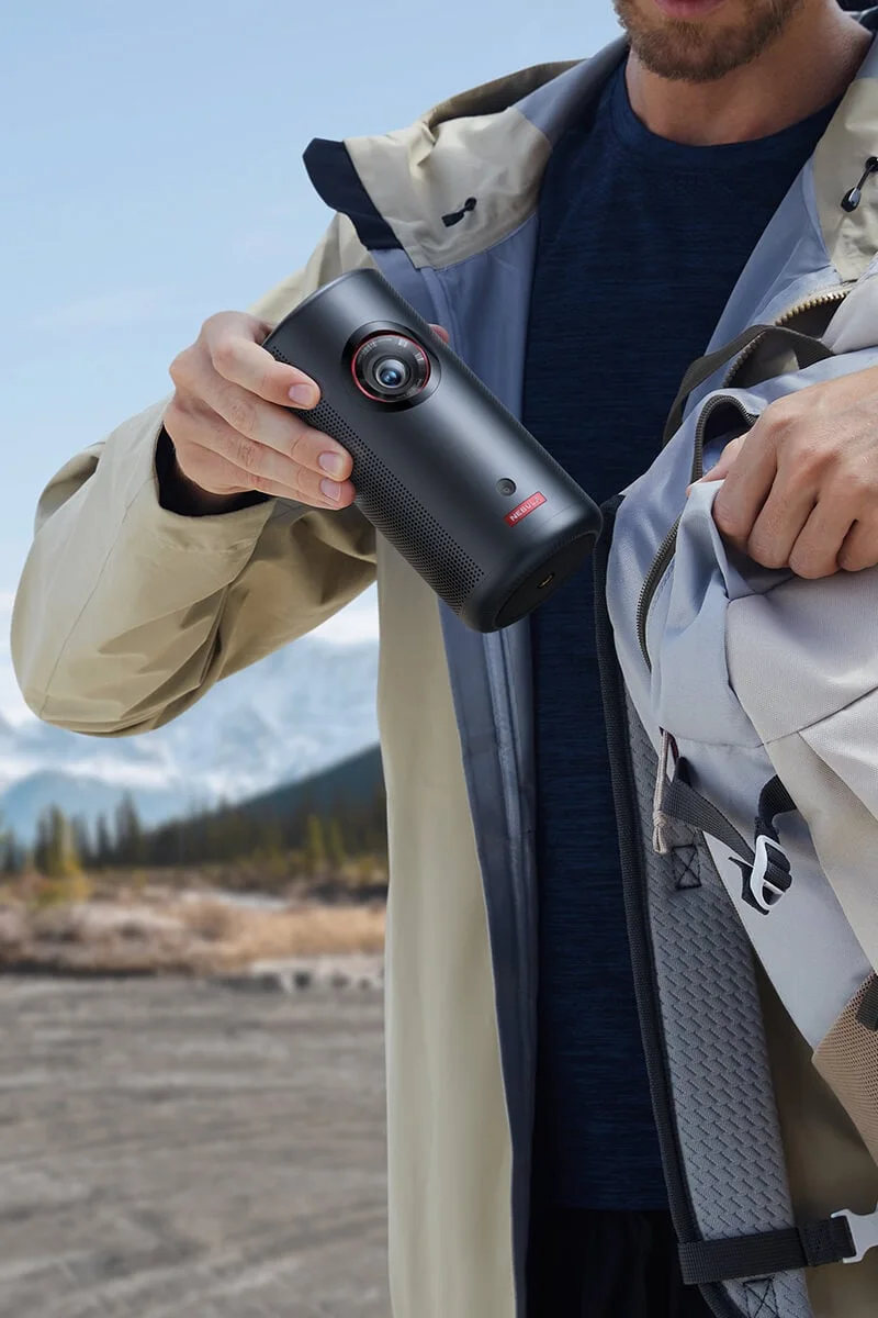 Traveler placing a Nebula Capsule 3 Laser projector in a backpack