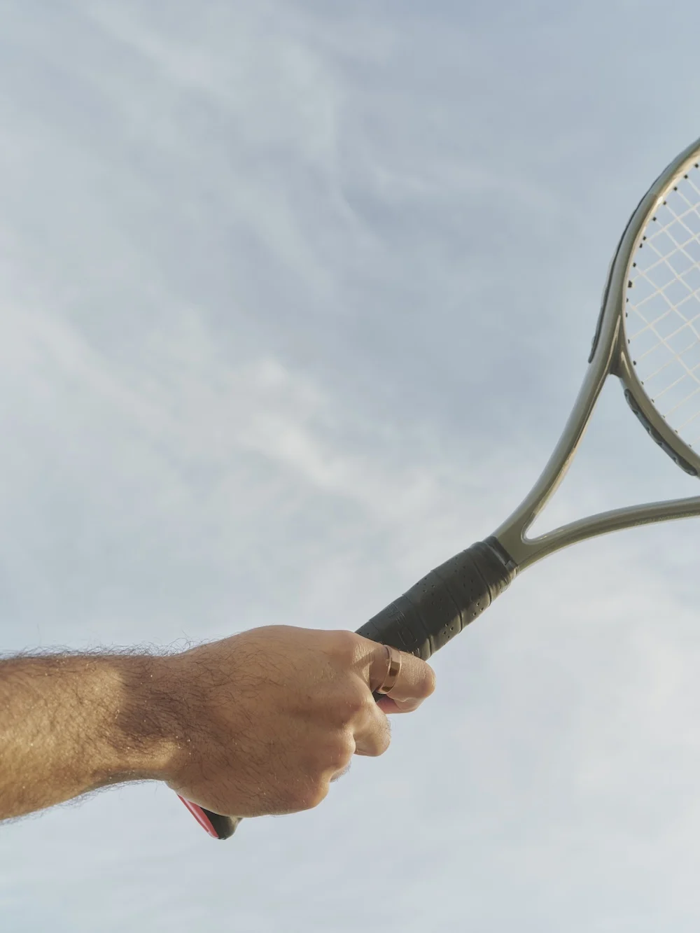 Oura Ring 5 worn while holding a tennis racket
