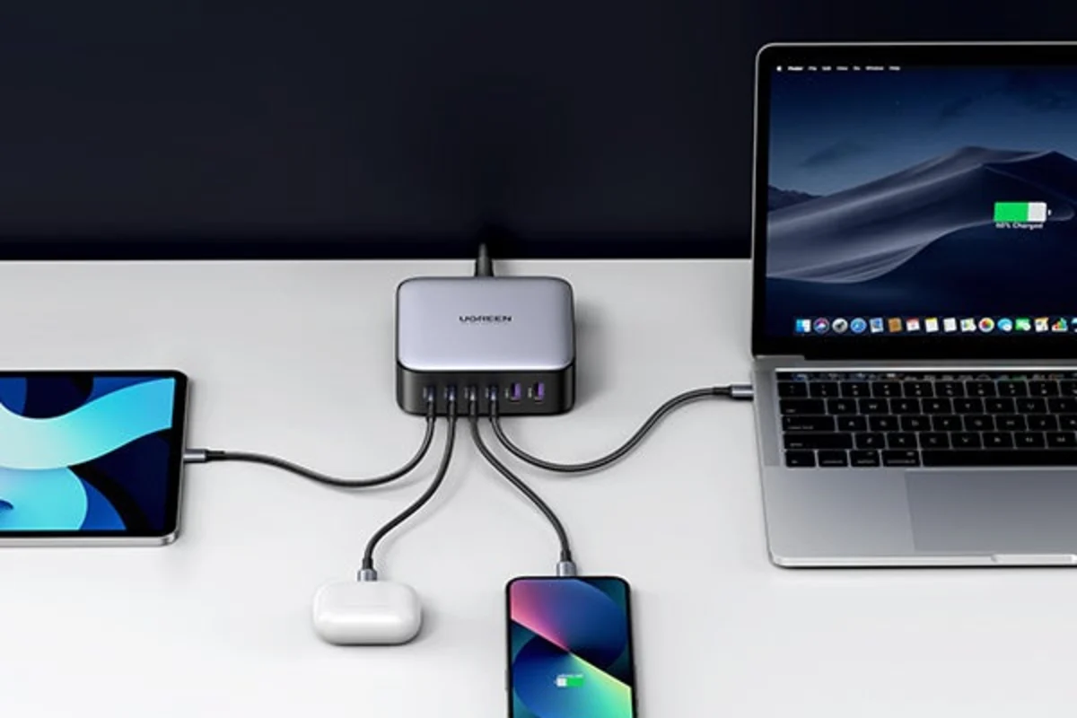 UGREEN Nexode 200W charging a laptop, tablet, phone, and earbuds on a desk